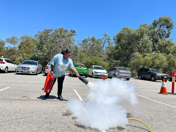 Participant using fire extinguisher on live fire